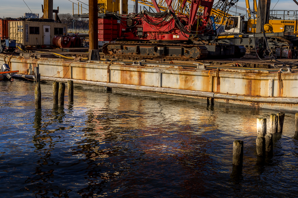 Relections of crane and barge ripple with the water